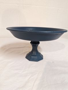 a blue bowl sitting on top of a white table