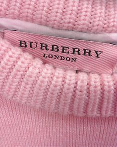 a pink sweater with the name burbery london on it's chest pocket