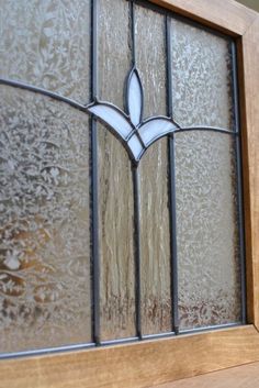 an old stained glass window with leaves on it