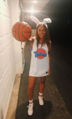 a woman in bunny ears holding a basketball