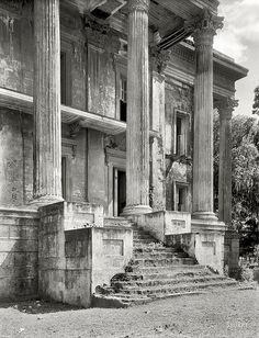 an old black and white photo of stairs leading up to a large building with columns