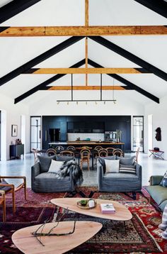 a living room filled with lots of furniture and a wooden ceiling mounted to the wall