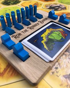 a board game with wooden blocks and blue plastic figures on it, including a map