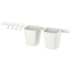 two white cups are hanging on the wall and one is holding hooks for each cup