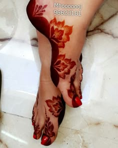 a woman's feet with hennap and flowers on the bottom of them