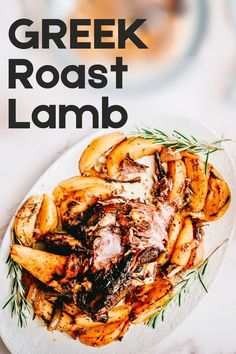 a white plate topped with roast lamb covered in sauce and garnished with rosemary