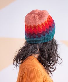 a woman with long hair wearing a multicolored knitted hat on her head