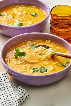 two bowls of soup with spoons on a table