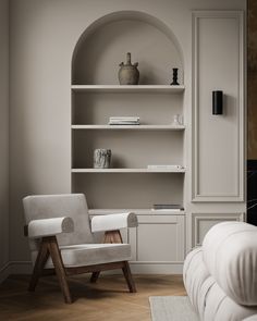 a white chair sitting in front of a book shelf