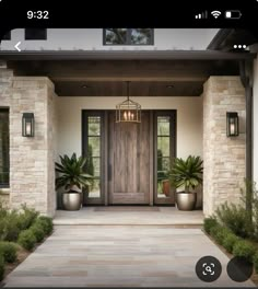 the front door to a house with potted plants on either side and an entry way