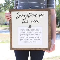 a woman holding up a sign that says, scripture of the week