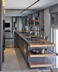 a kitchen with an island in the middle and stairs leading up to it's door