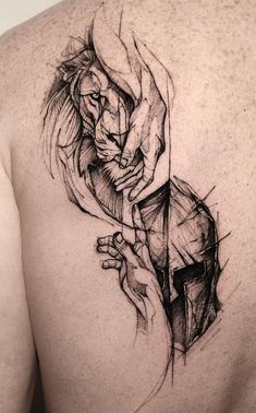 a man's back with a lion tattoo on his left shoulder and an arrow in the middle