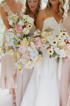 the bridesmaids are holding their bouquets together