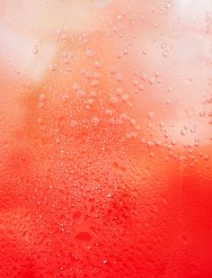 water drops on the surface of a red liquid