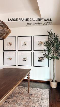 a room with pictures hanging on the wall and a table in front of it that has a potted plant