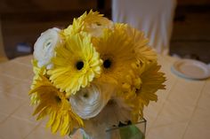 a vase filled with yellow and white flowers