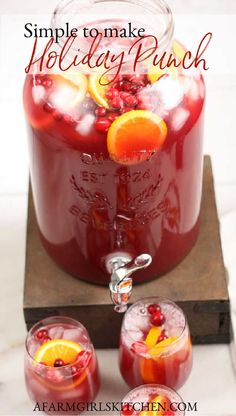 two glasses filled with cranberry punch and garnished with orange slices