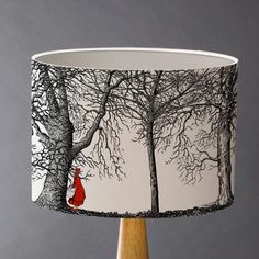 a lamp shade with a red fox sitting in the woods on it's side