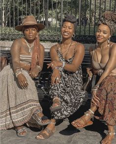 three women are sitting on a bench together