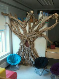 a room with chairs and a tree made out of branches