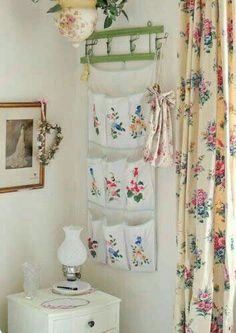 a white dresser sitting next to a window covered in curtains and hanging pictures on the wall