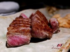 two pieces of meat sitting on top of a cutting board