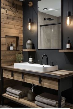 a bathroom sink sitting under a mirror next to a wooden shelf with towels on it