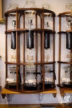 three wooden shelves filled with different types of coffee cups