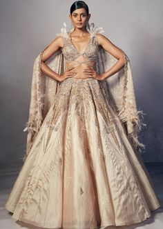 Champagne organza lehenga with shimmer tulle embellished cross strap blouse embroidered with micro Japanese cutdaana, sequins and crystal stones. Teamed with chiffon chikankari & kamdani dupatta edged with an embroidered border. Glamorous Hand Embellished Organza Sharara, Glamorous Tissue Silk Sets For Reception, Glamorous Tissue Silk Lehenga For Designer Wear, Glamorous Embellished Organza Choli, Embellished Organza Sharara In Glamorous Style, Glamorous Embellished Organza Sharara, Glamorous Organza Choli With Dupatta, Glamorous Lehenga With Intricate Embroidery In Georgette, Glamorous Georgette Lehenga With Intricate Embroidery