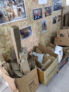 cardboard boxes are stacked on the floor in front of pictures