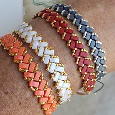 a close up of a person's arm wearing different colored bracelets