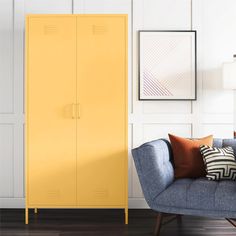 a living room with a blue couch and yellow cabinet