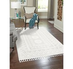 a white rug with tassels on it in a living room