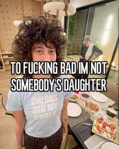 a man with curly hair standing in front of a table filled with plates and food