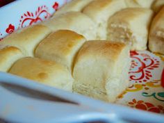 a plate that has some bread on it and a knife in the bowl next to it