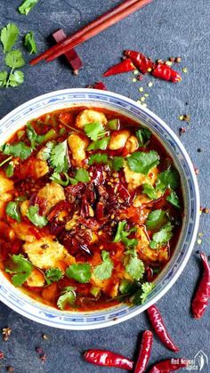 a bowl filled with food and garnished with cilantro, red chili peppers