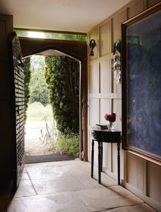 an open door leading into a room with a table and vase on it's side