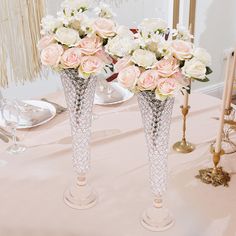 two vases filled with pink and white flowers on a table