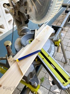 a piece of wood sitting on top of a table next to a planer blade