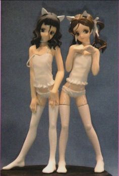 two figurines that are standing next to each other