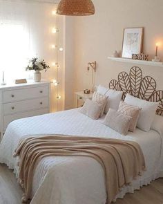 a bedroom with white furniture and lights on the wall