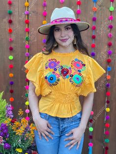 This beautiful Flounce Sleeve Top is the perfect Top for a fun day out or special event. The adorable fluttery sleeves and colorful hand embroidered flowers make it flirty and fun. It's made out of fine Mexican cotton, has an elastic waist and has colorful flowers embroidered completely by hand. This blouse is made with love by Mexican Artisans in Chiapas, Mexico. Please note: This blouse comes in one size which fits sizes Small and Medium. Purchase the Mexican hats here: https://www.etsy.com/es Yellow Bohemian Tops For Festive Occasions, Festive Bohemian Yellow Tops, Yellow Festive Tops For Summer, Festive Yellow Summer Tops, Yellow Bohemian Tops For Festivals, Multicolor Fitted Peasant Top For Summer, Yellow Folk Style Blouse For Spring, Yellow Folk Style Spring Blouse, Traditional Fitted Embroidered Summer Top