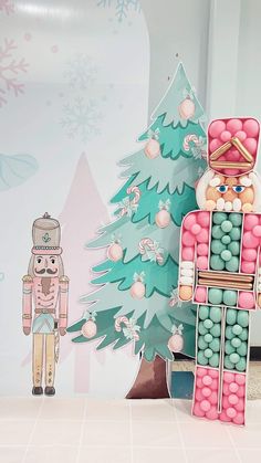 a nutcracker standing next to a christmas tree with candy in its mouth and an ornament behind it