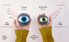 two hands are holding an eyeball made from yarn and felt, with measurements for the size