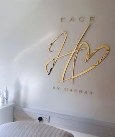 there is a white bed in front of the face shop logo on the wall above it