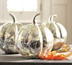 three glass pumpkins sitting on top of a table