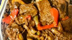 meat and vegetables are mixed together in a white bowl on a blue and yellow tablecloth