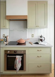 a kitchen with green cabinets and white counter tops