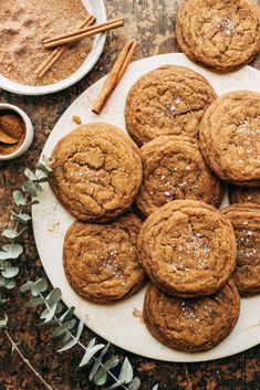 a plate full of cookies and cinnamons on a table with some spices next to it